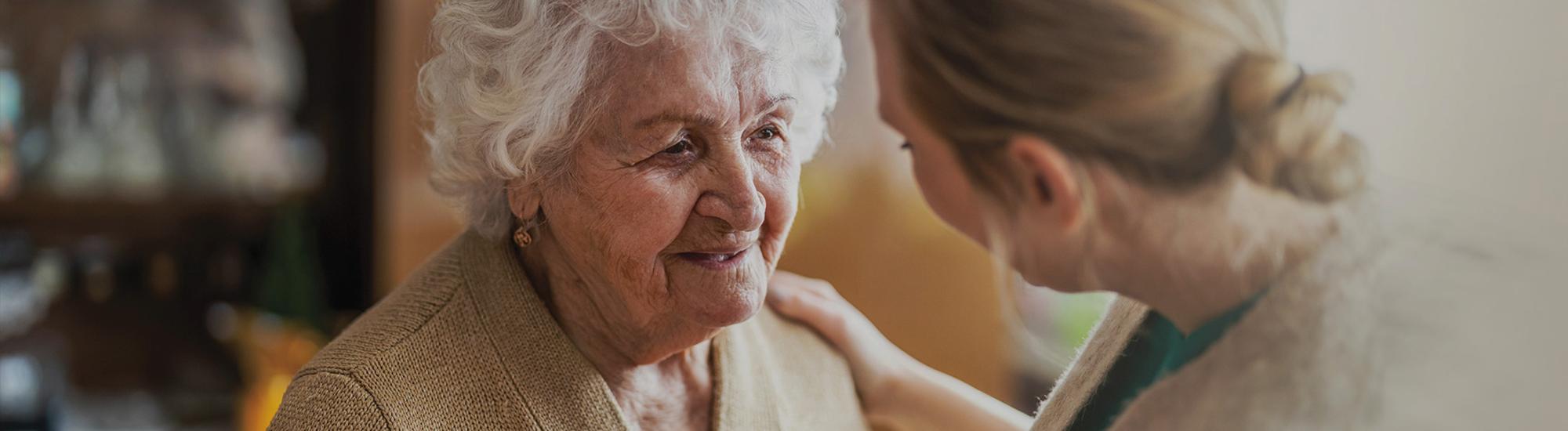 Woman interacting with an elderly woman in a warm indoor setting